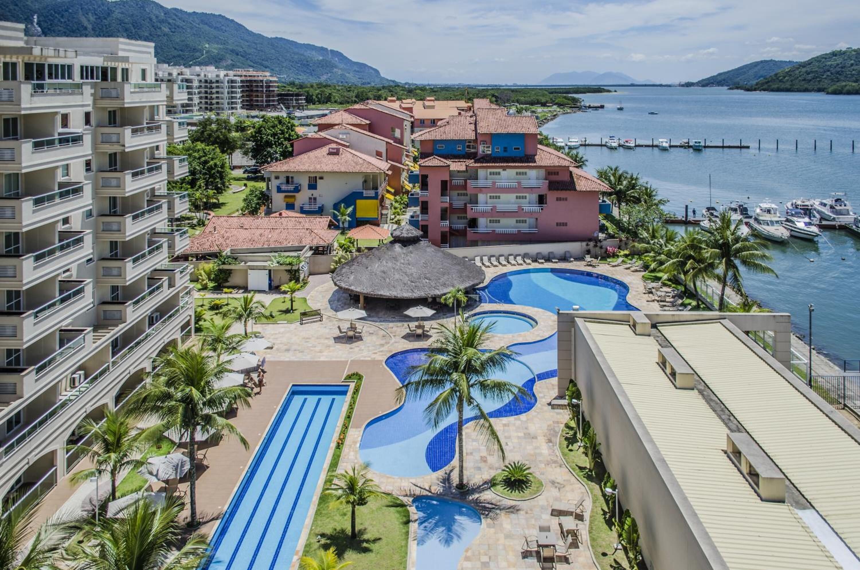 A resort with multiple swimming pools, a beach area, and a marina.