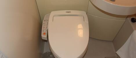 Un baño pequeño con inodoro, lavabo y panel de control.