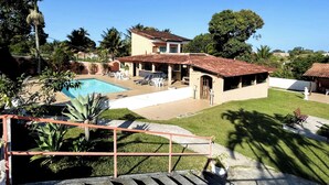 A house with a swimming pool, outdoor seating, and a garden.