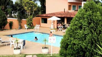 Relax by the serene pool surrounded by lush greenery and comfortable lounge chairs.