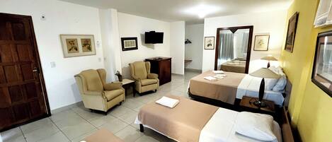 A hotel room with two beds, a TV, a desk, and a chair.