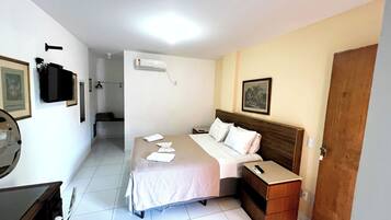 Ein Hotelzimmer mit Bett, Nachttisch und Spiegel.
