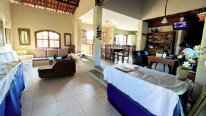 A spacious living area with a high ceiling, a dining area, and a kitchen.