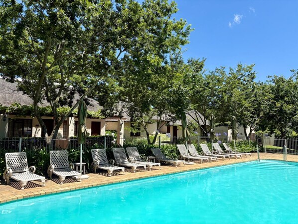 حمّام سباحة خارجي، مظلات على حمّام السباحة، مقاعد للتشمس