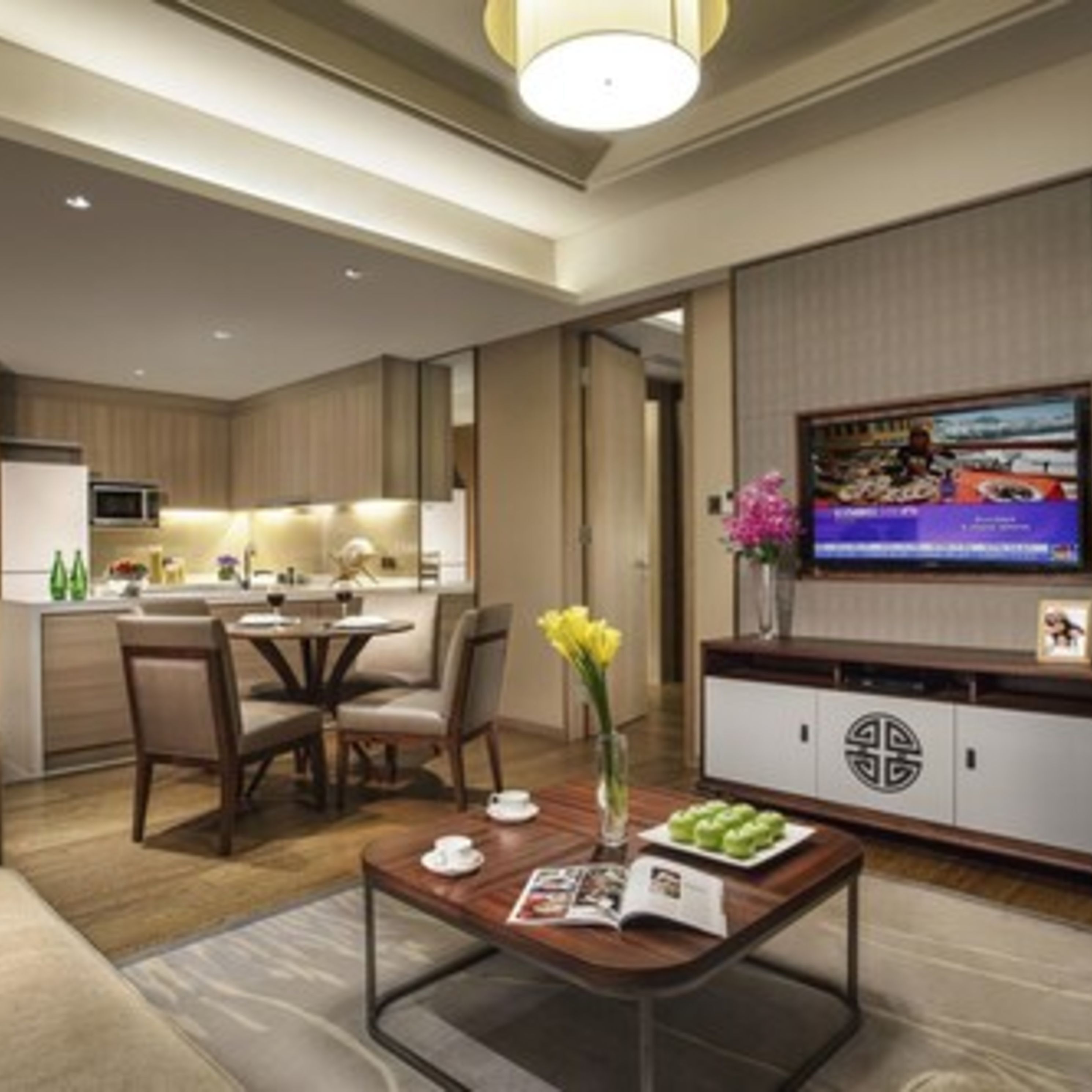 Ett modernt hotellrum med en matplats, en tv och en dekorativ vas.
