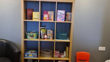Children can play and read in this room's designated play area, featuring a bookshelf and toys.