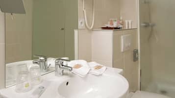 A modern bathroom with a sink, toilet, and glass shower enclosure.