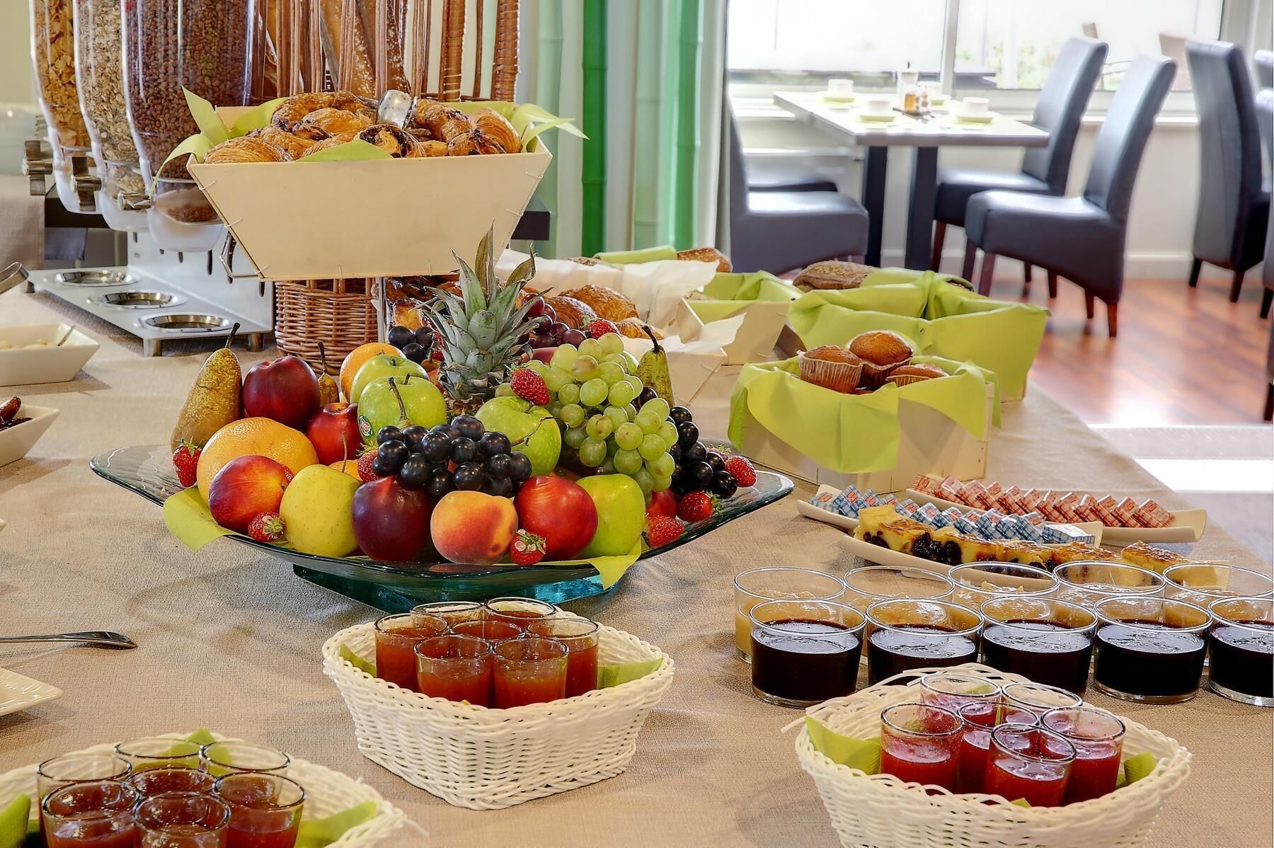 A buffet with fruits, pastries, and beverages.