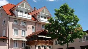A multi-story building with a balcony, signage indicating a restaurant, and a tree in front. - Zum Hirschen (Donaueschingen)