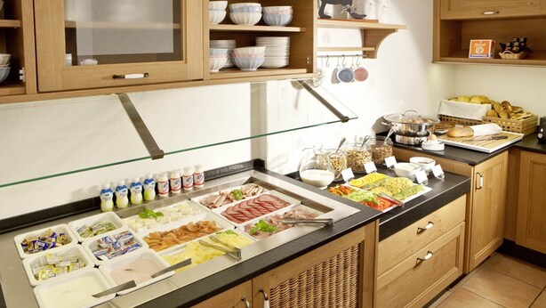 A buffet setup with various food items and condiments. - Gasthof Lerner (Freising)