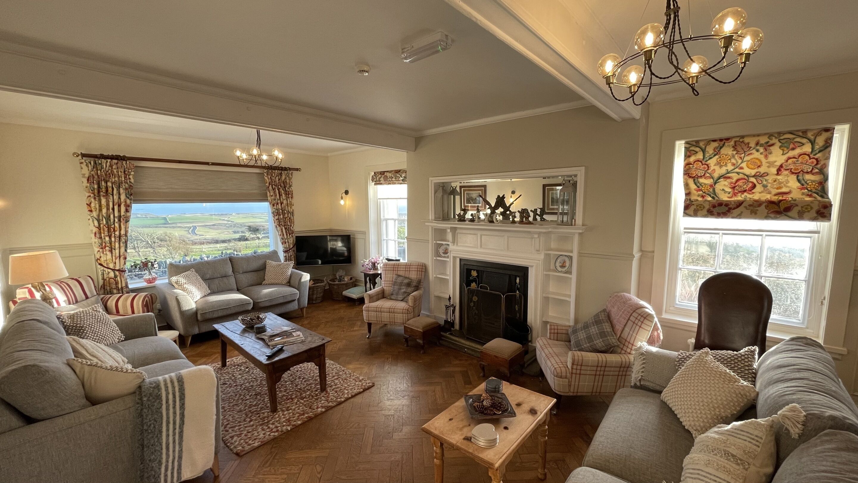 A cozy living room with a fireplace, comfortable seating, and a view of the outdoors.