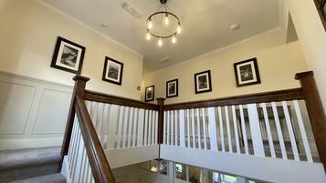 Una escalera con barandas de madera y un candelabro.