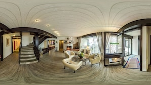 A spacious living area with a curved ceiling, a staircase, and a seating arrangement. - Hotel Brandl (Bad Woerishofen)