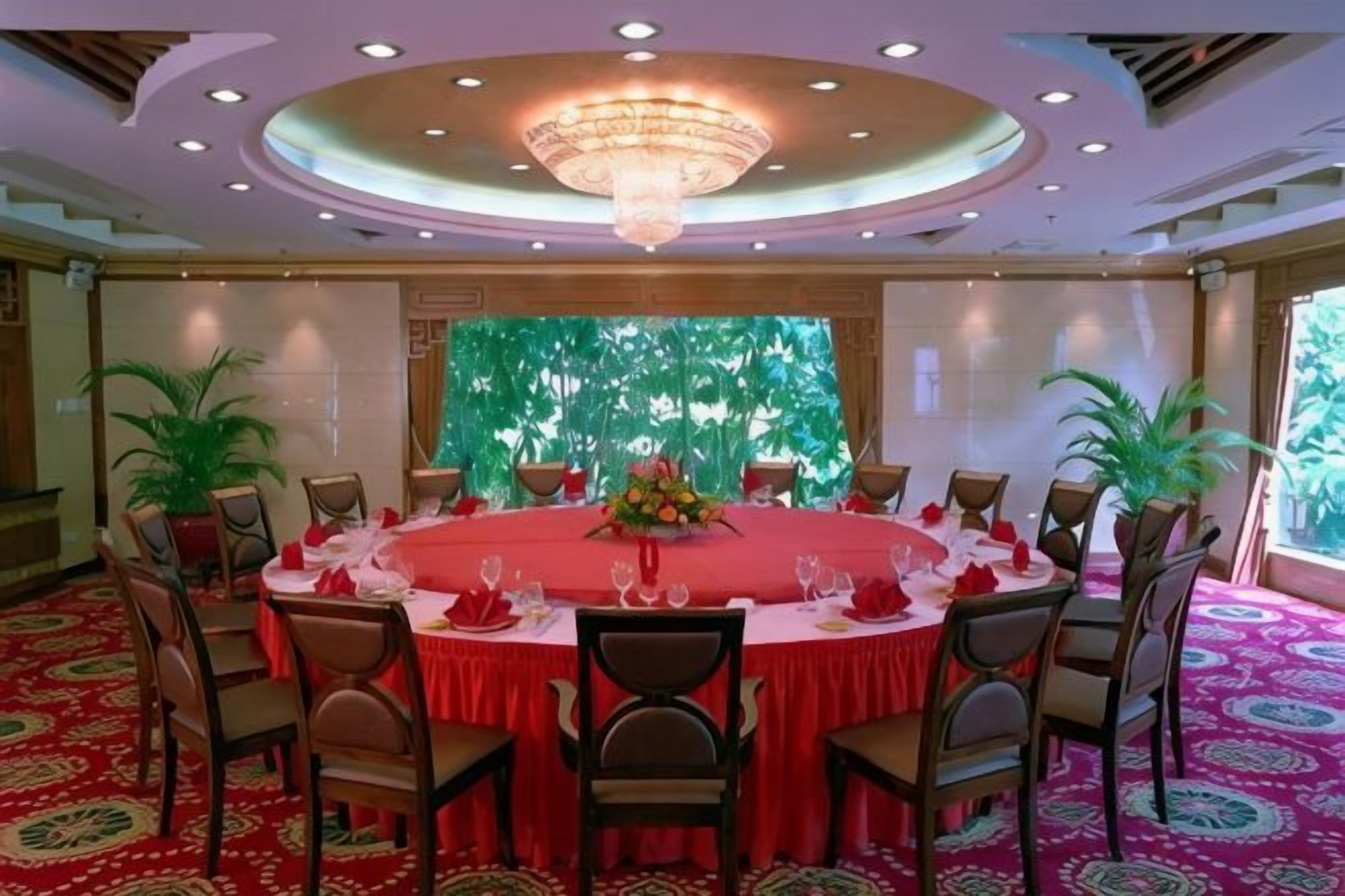 A conference room with a round table, chairs, and a chandelier.