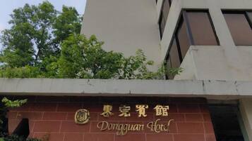 A building with a sign that reads 'Dongguan Hotel.'