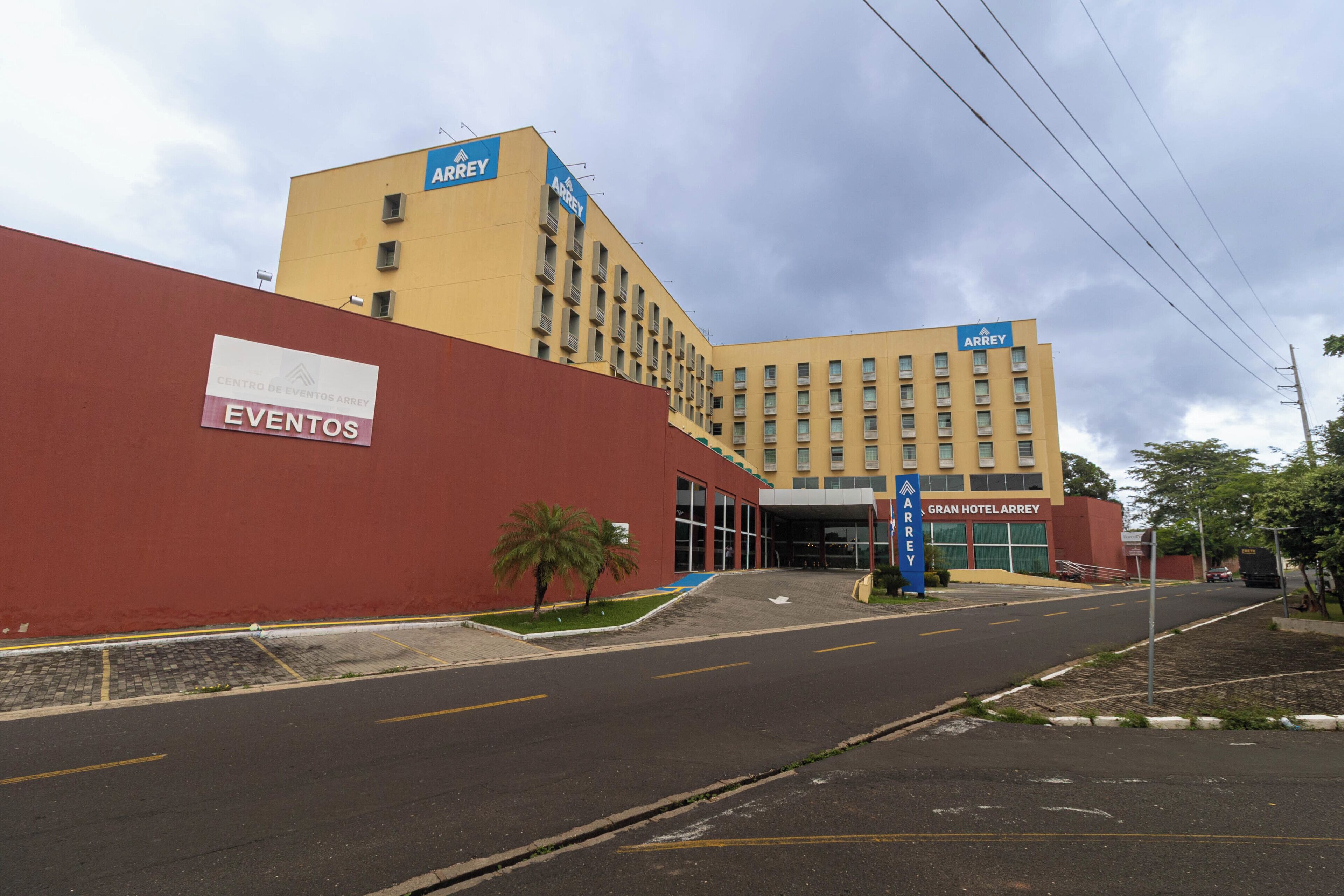 A hotel with a red exterior wall, a sign for 'EVENTOS,' and a 'GRAN HOTELARREY' sign.