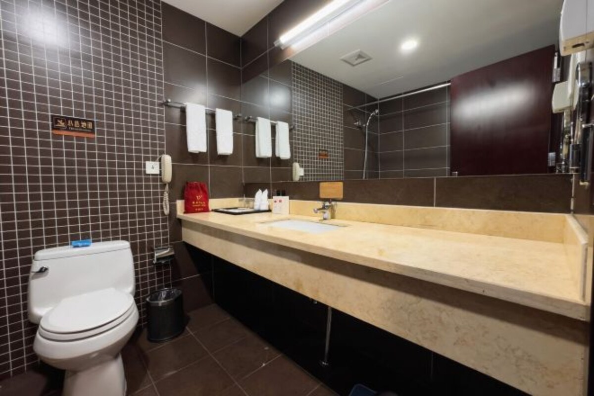 A modern bathroom with a toilet, sink, and mirror.