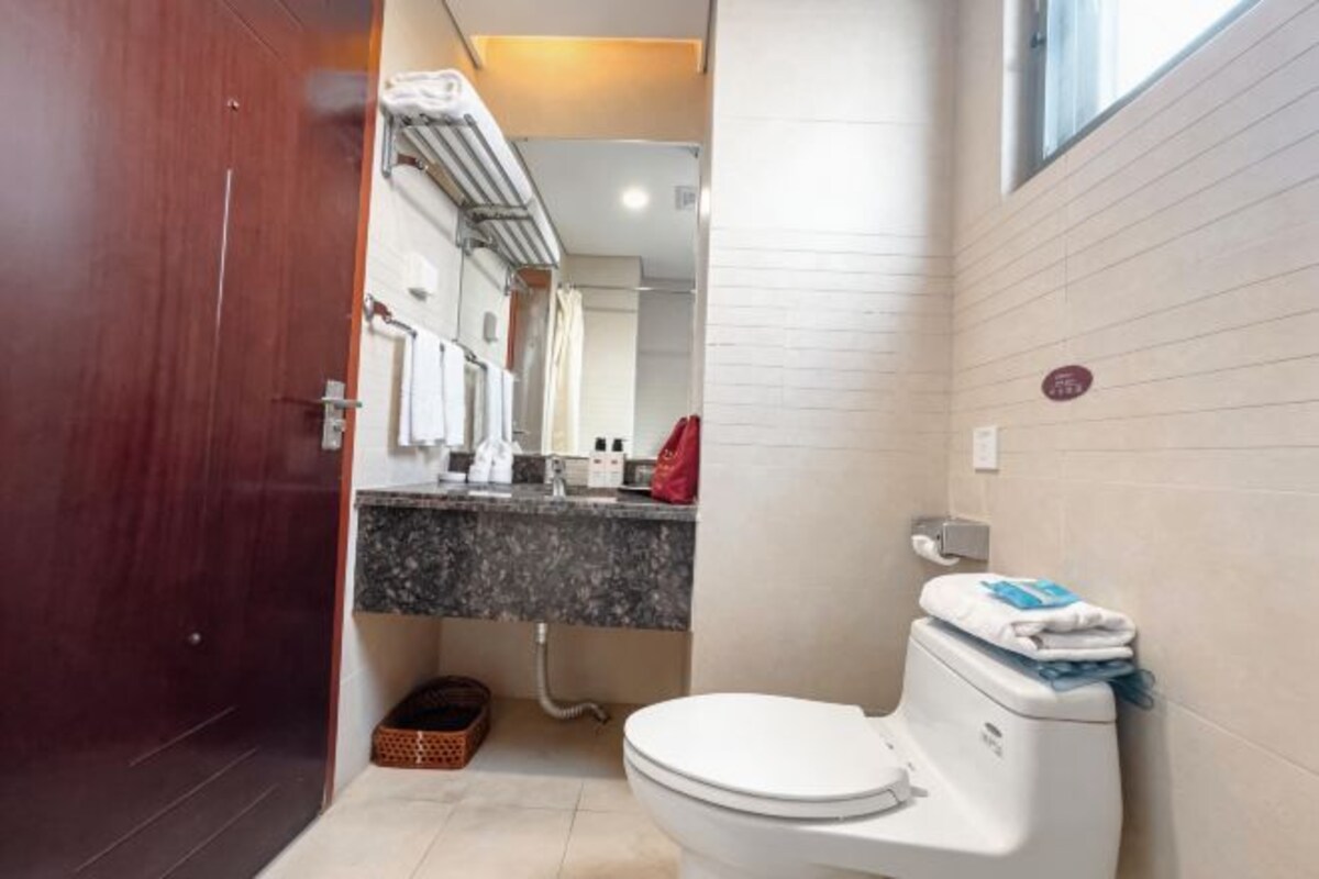 A bathroom with a toilet, a sink, and a window.