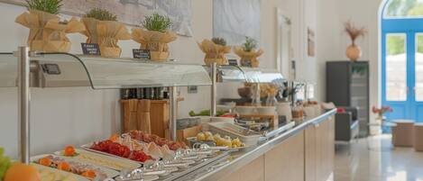 A buffet with various food items and small potted plants.