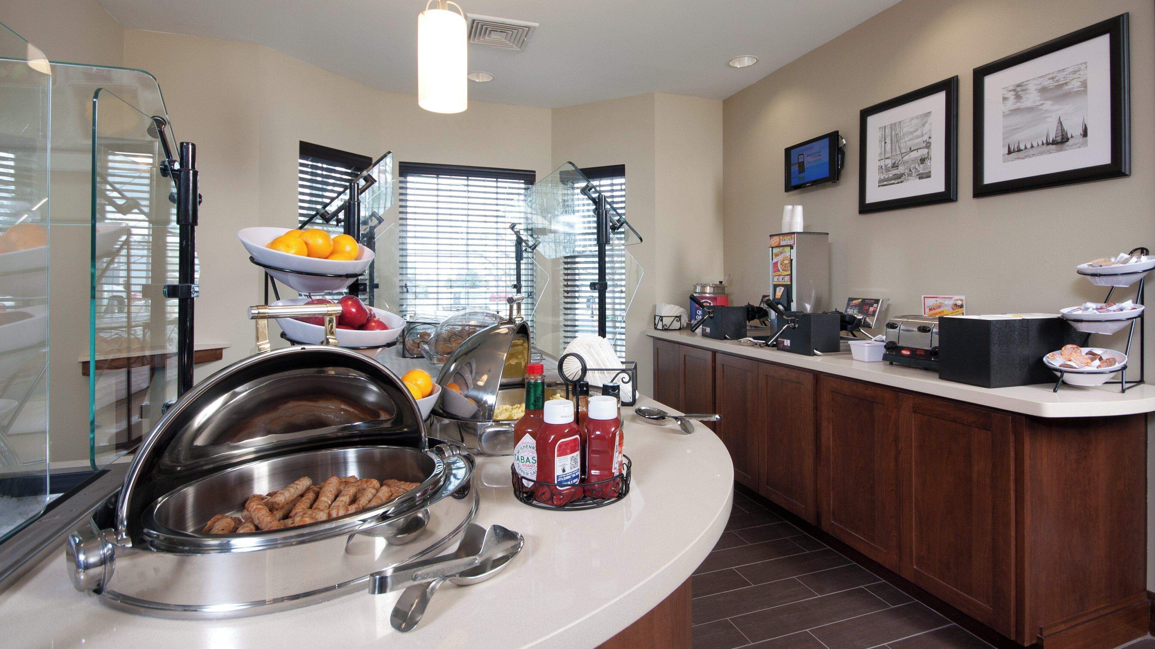 A buffet setup with various food items and condiments.