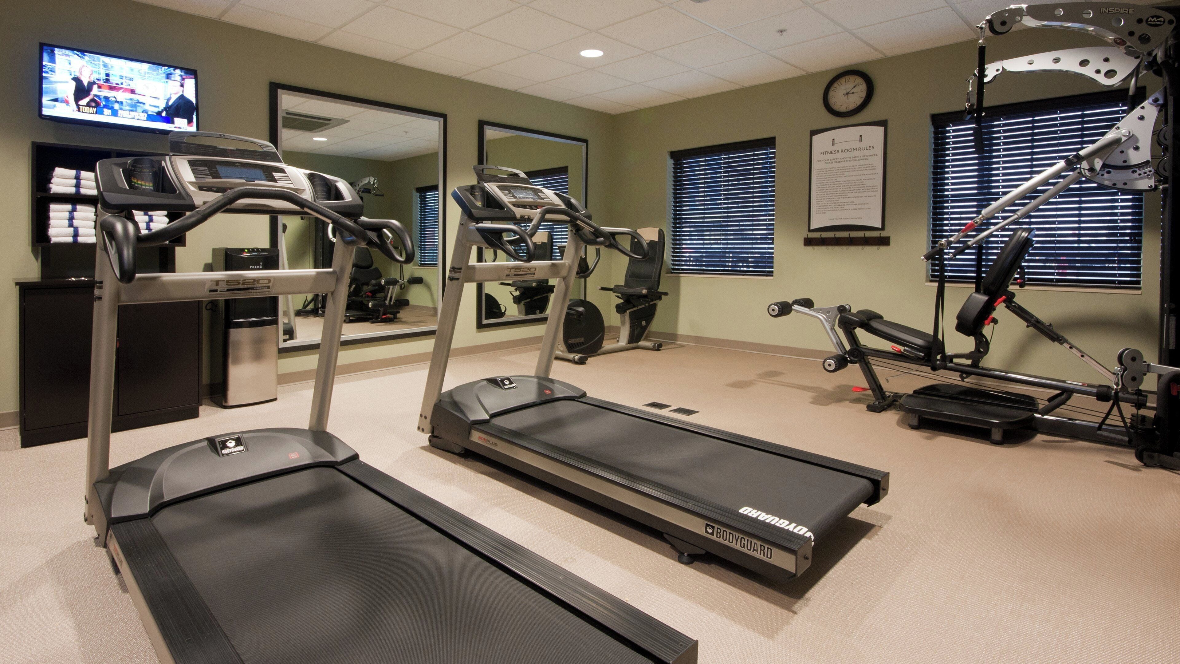 A fitness room with treadmills, a stationary bike, and a rowing machine.