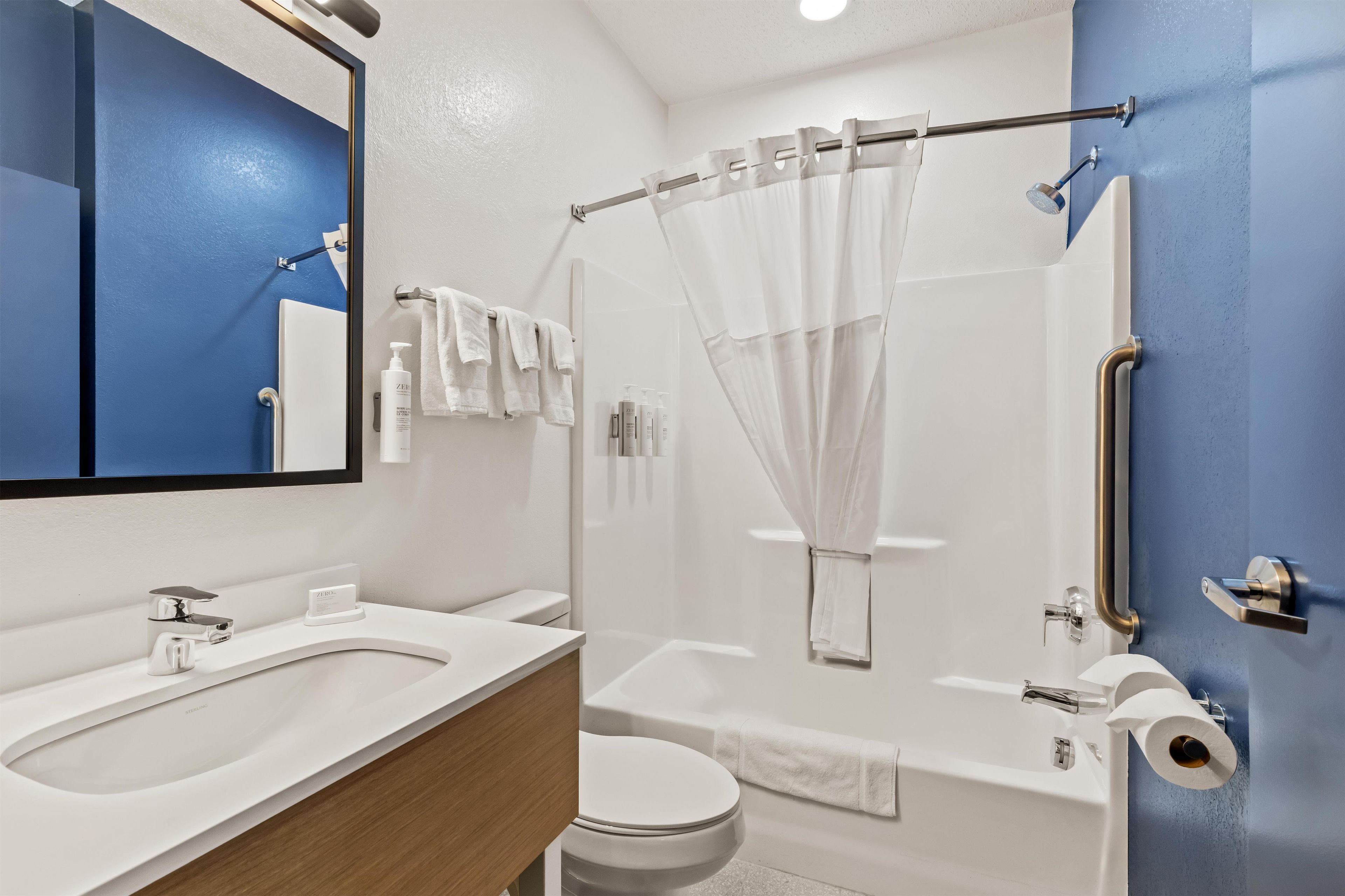 A modern bathroom with a shower, toilet, and sink.
