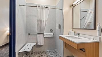 Ein modernes Badezimmer mit Dusche, Waschbecken und Spiegel.