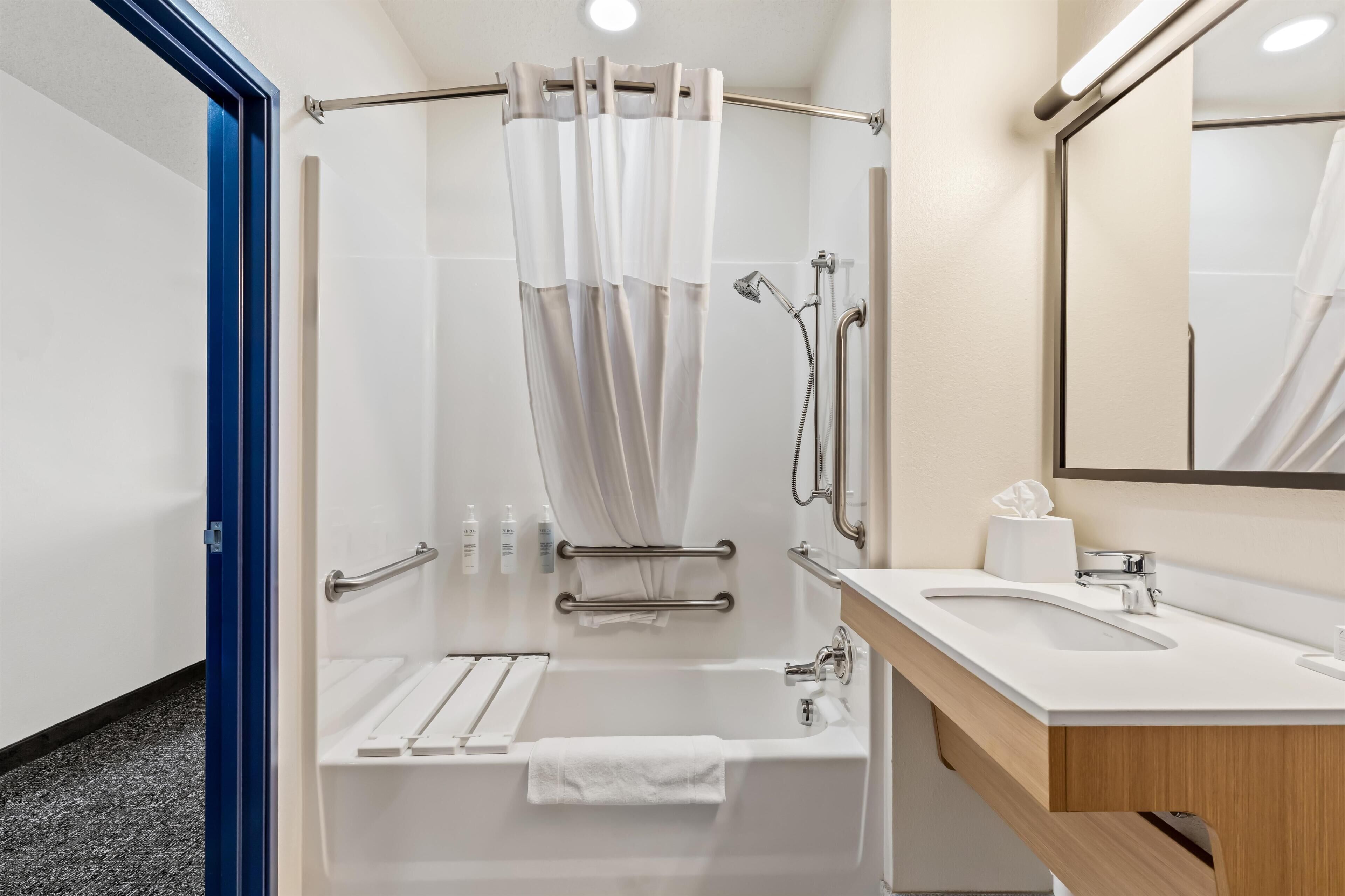 Une salle de bain moderne avec une douche, un lavabo et un miroir.