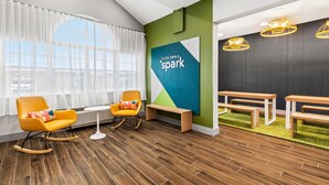 Un espacio de oficina moderno con dos sillones mecedores, un banco y una mesa.