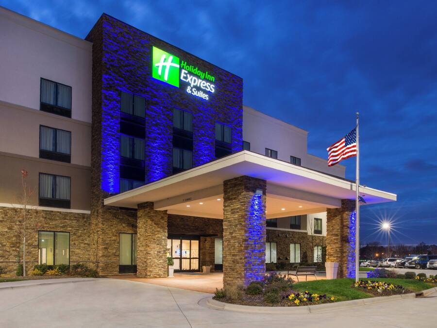 Um hotel Holiday Inn Express & Suites com fachada de pedra e iluminação azul.