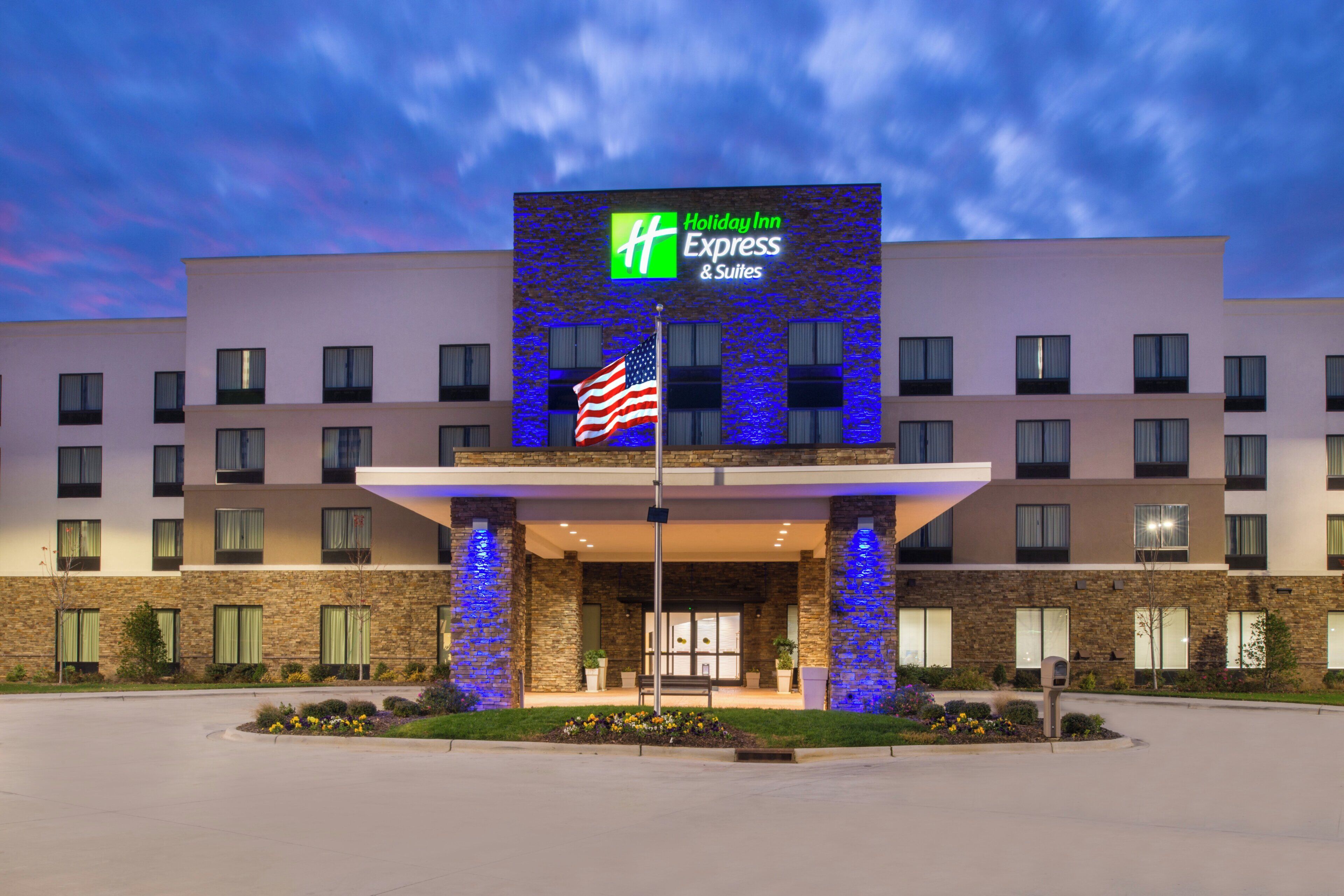 A Holiday Inn Express & Suites hotel with a brick facade and a large entrance.