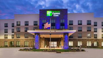 A Holiday Inn Express & Suites hotel with a brick facade and a large entrance.