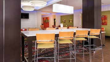 Un comedor moderno con una mesa larga, múltiples sillas e iluminación contemporánea.