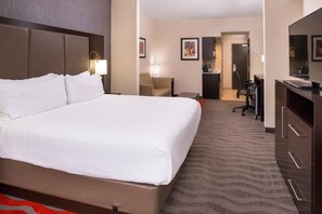 A hotel room with a large bed, a desk, a chair, a kitchenette, and a bathroom. - Holiday Inn Express & Suites Monroe by IHG (Monroe)