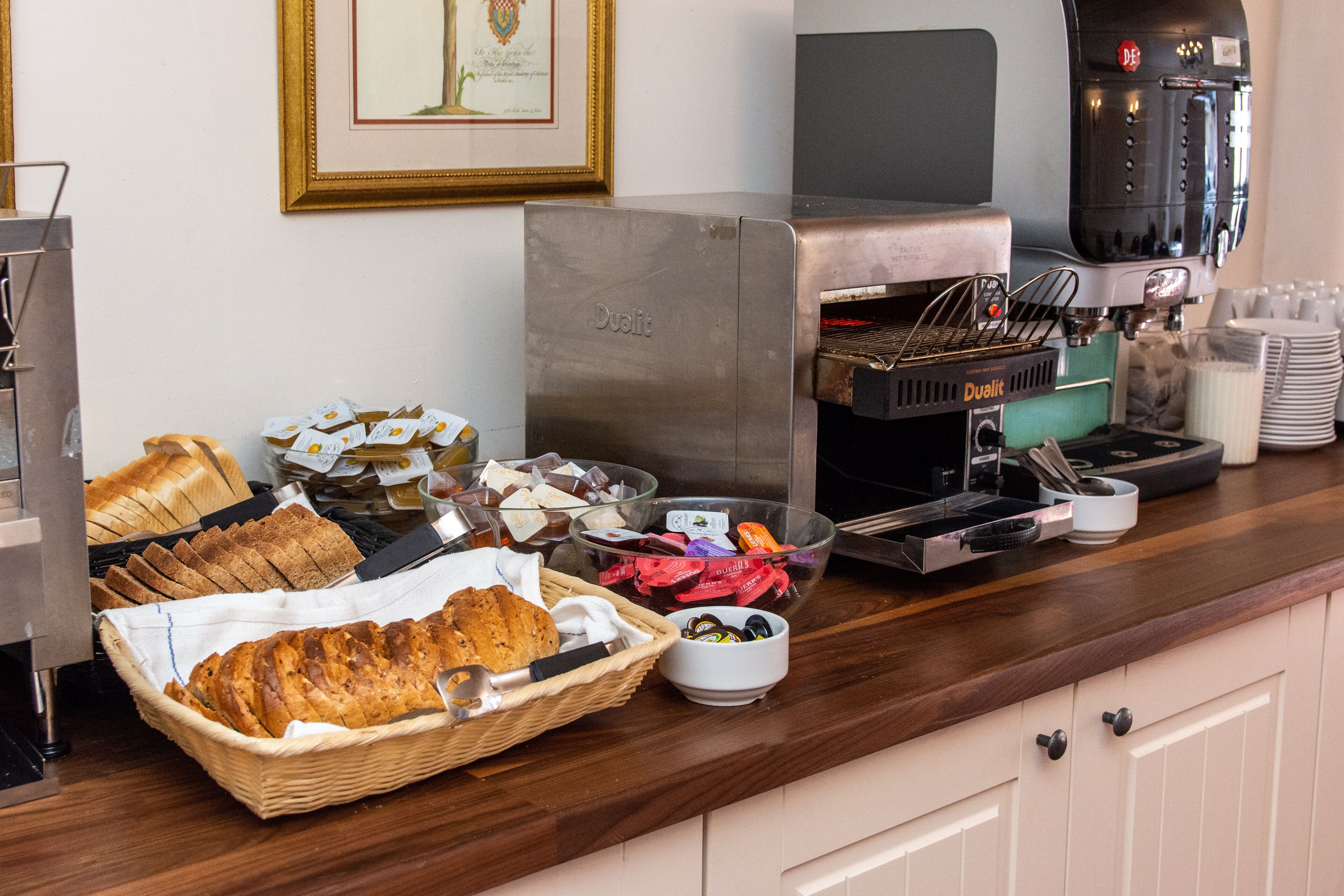 Een ontbijtbuffet met diverse gerechten, waaronder brood, gebak en toevoegingen.