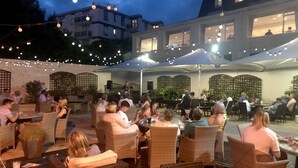 An outdoor dining area with wicker furniture and string lights. - TLH Derwent Hotel - TLH Leisure, Entertainment and Spa Resort (Torquay)