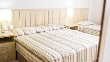 A hotel room with a large bed, two bedside tables, and a wooden headboard.