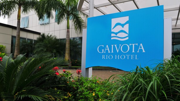 Une enseigne pour l’hôtel Gaivota Rio, avec un bâtiment moderne en arrière-plan.