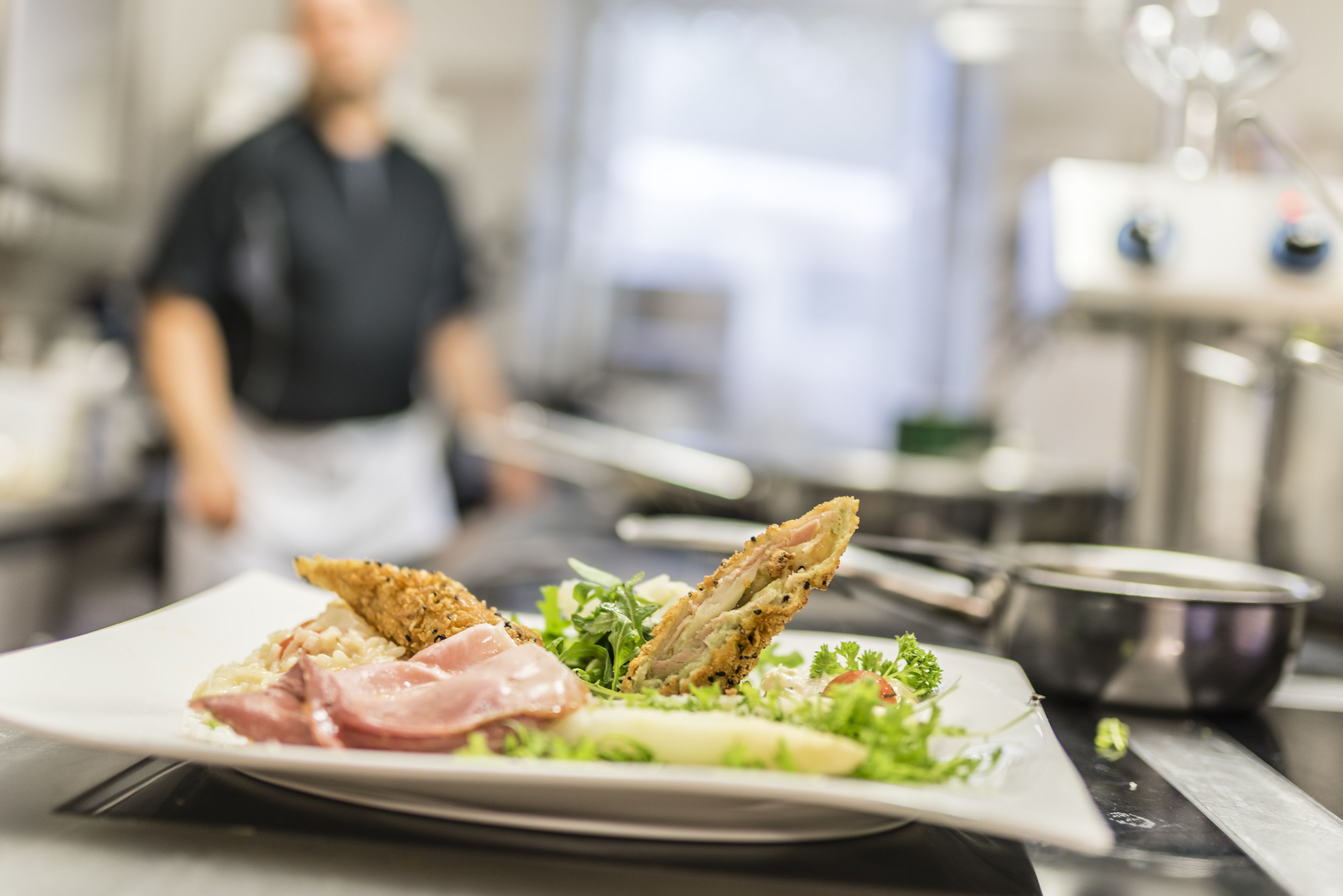 A plate of food with a salad and two pieces of breaded chicken, set on a table in a kitchen.