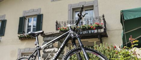 Una bicicleta de montaña estacionada frente a un edificio con un letrero que dice 'Wirtshaus Lener Hof'.