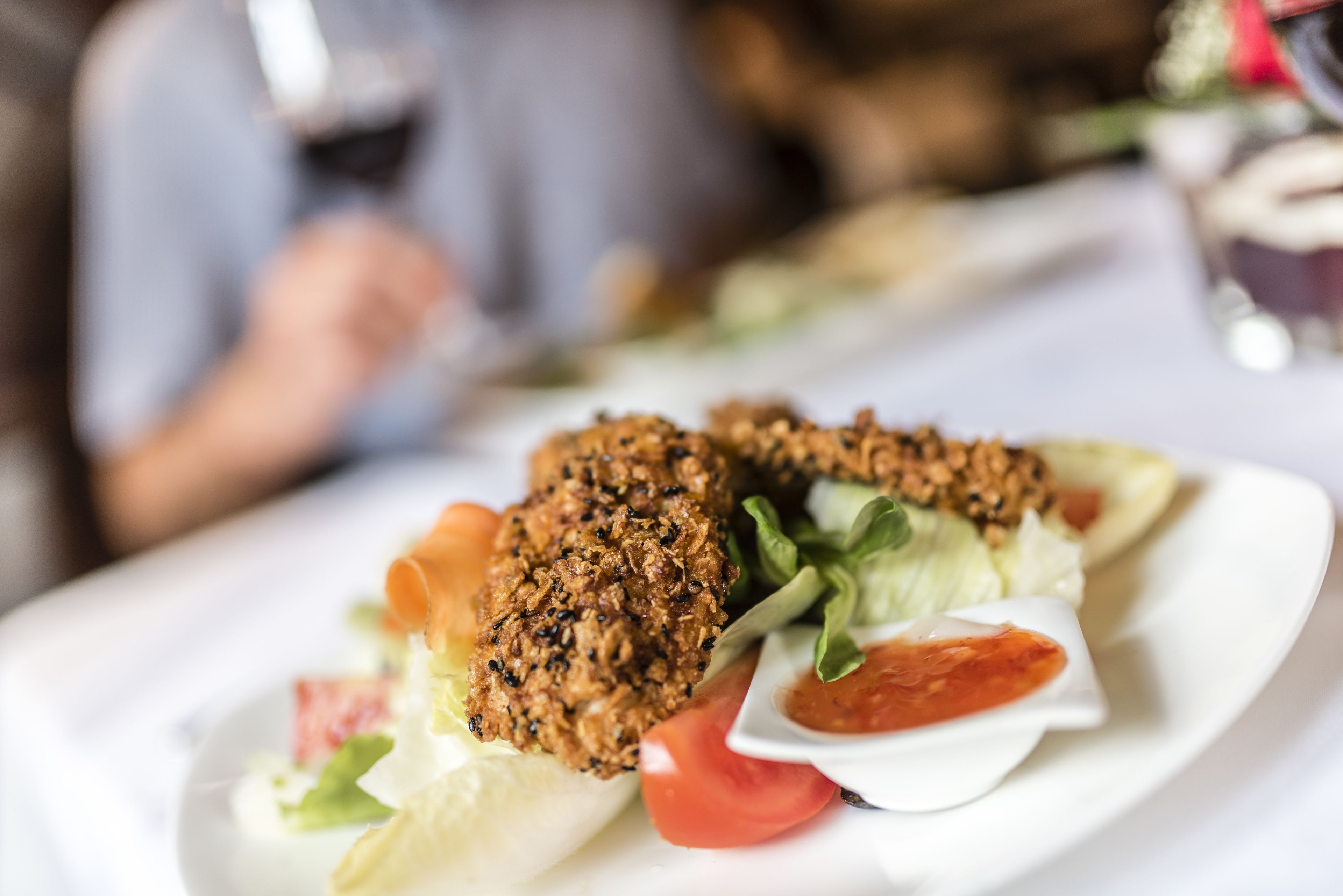Ein Teller Essen mit Salat und einer kleinen Schale Soße.