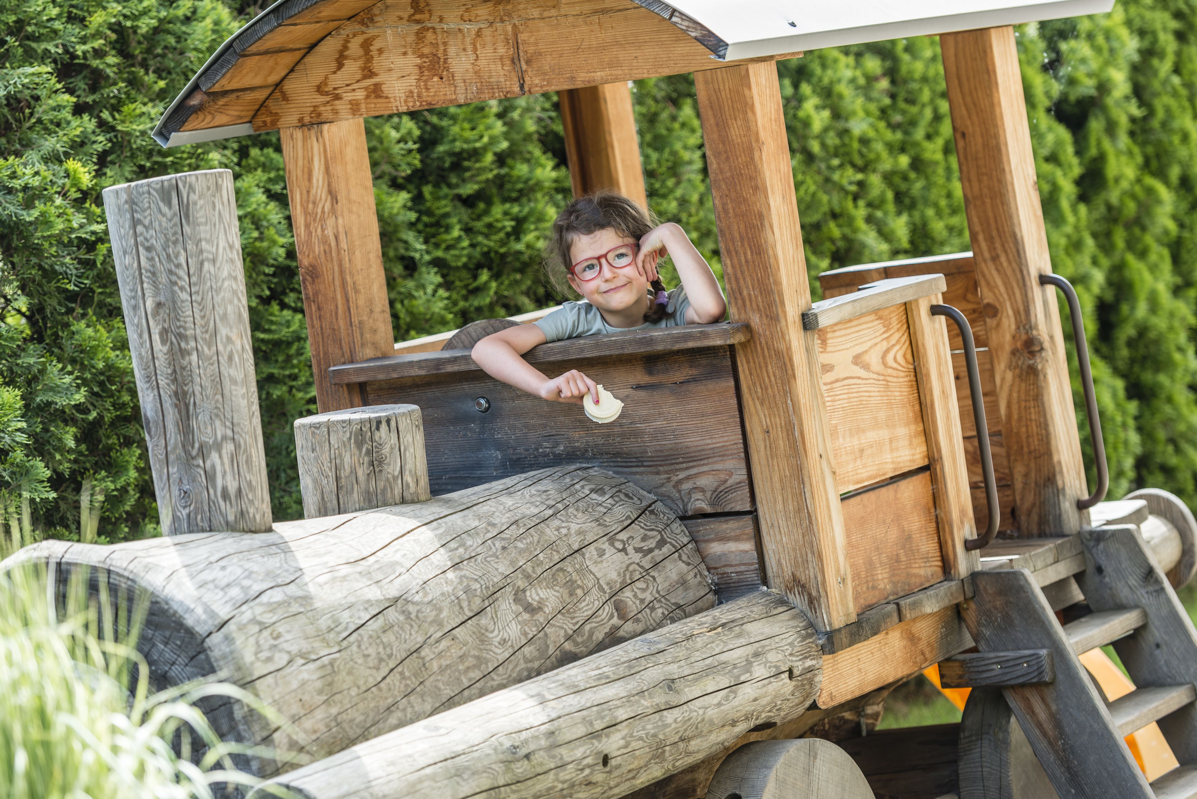 Eine Holzspielstruktur mit Rutsche und Bank.