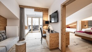 A modern bedroom with a wooden floor, a bed, a desk, a chair, and a TV. - Lener Wirtshaus & Hotel (Campo di Trens)