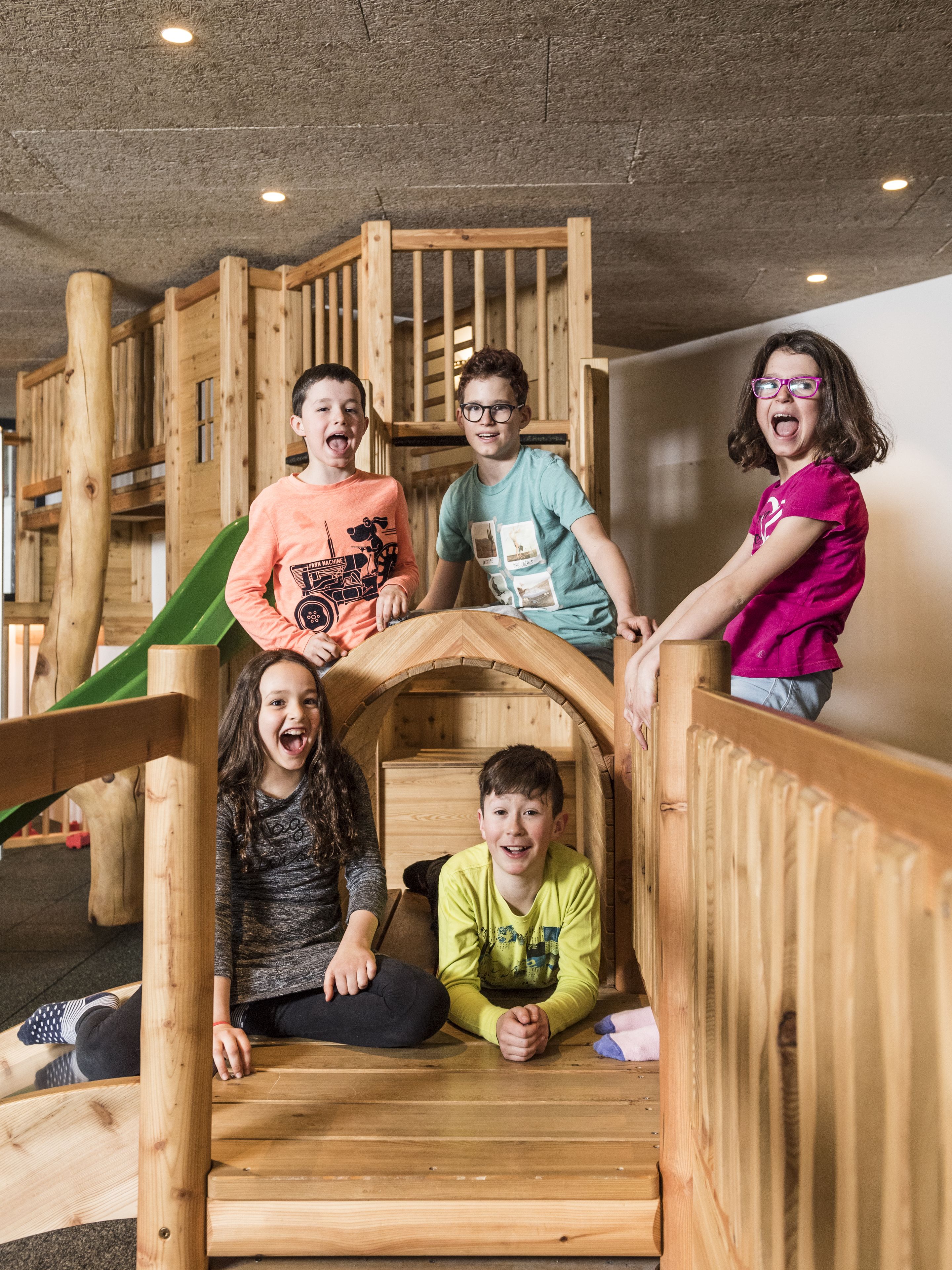 A wooden play structure with a slide and a small enclosed area.