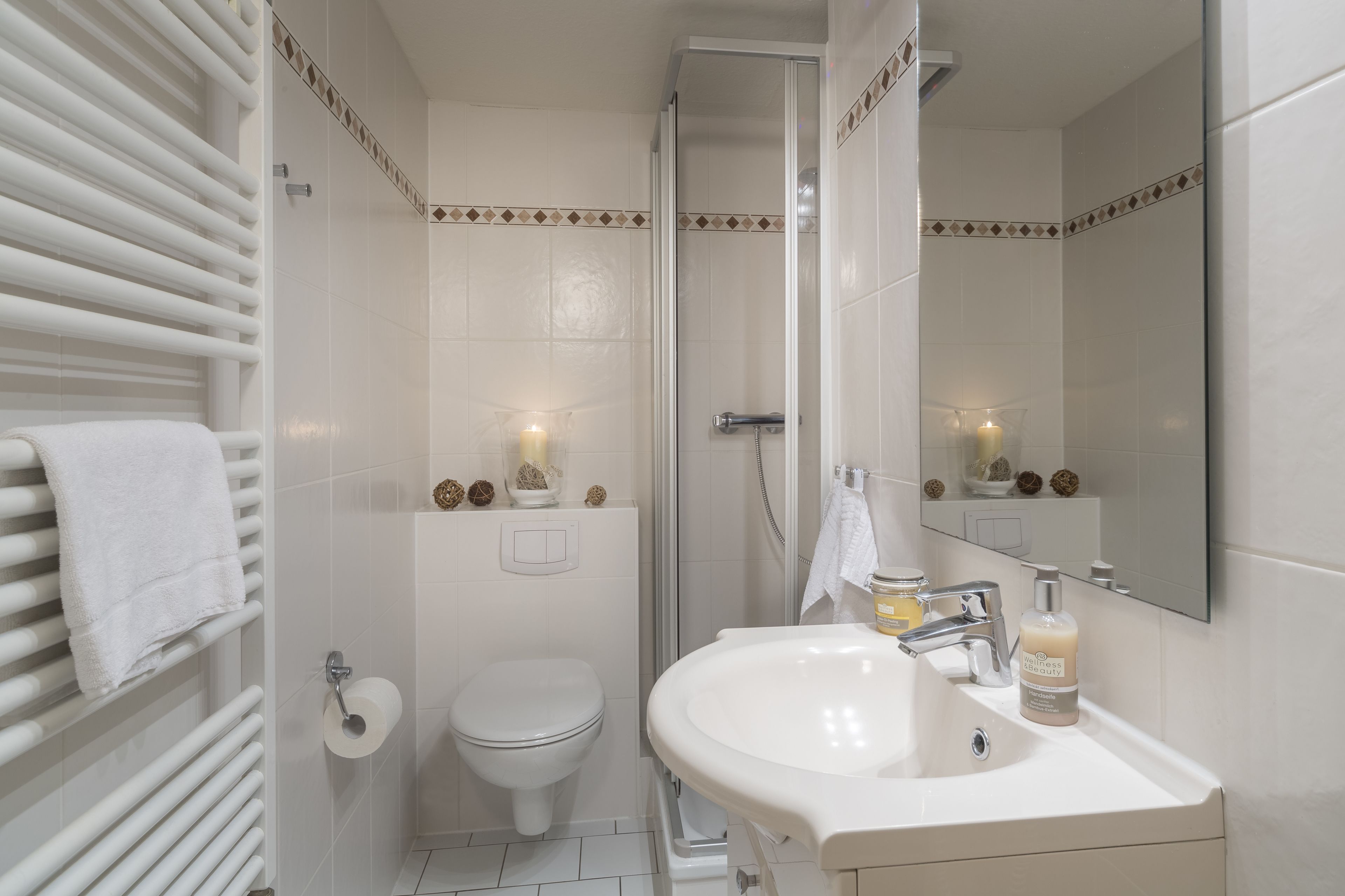 A bathroom with a toilet, sink, and shower.