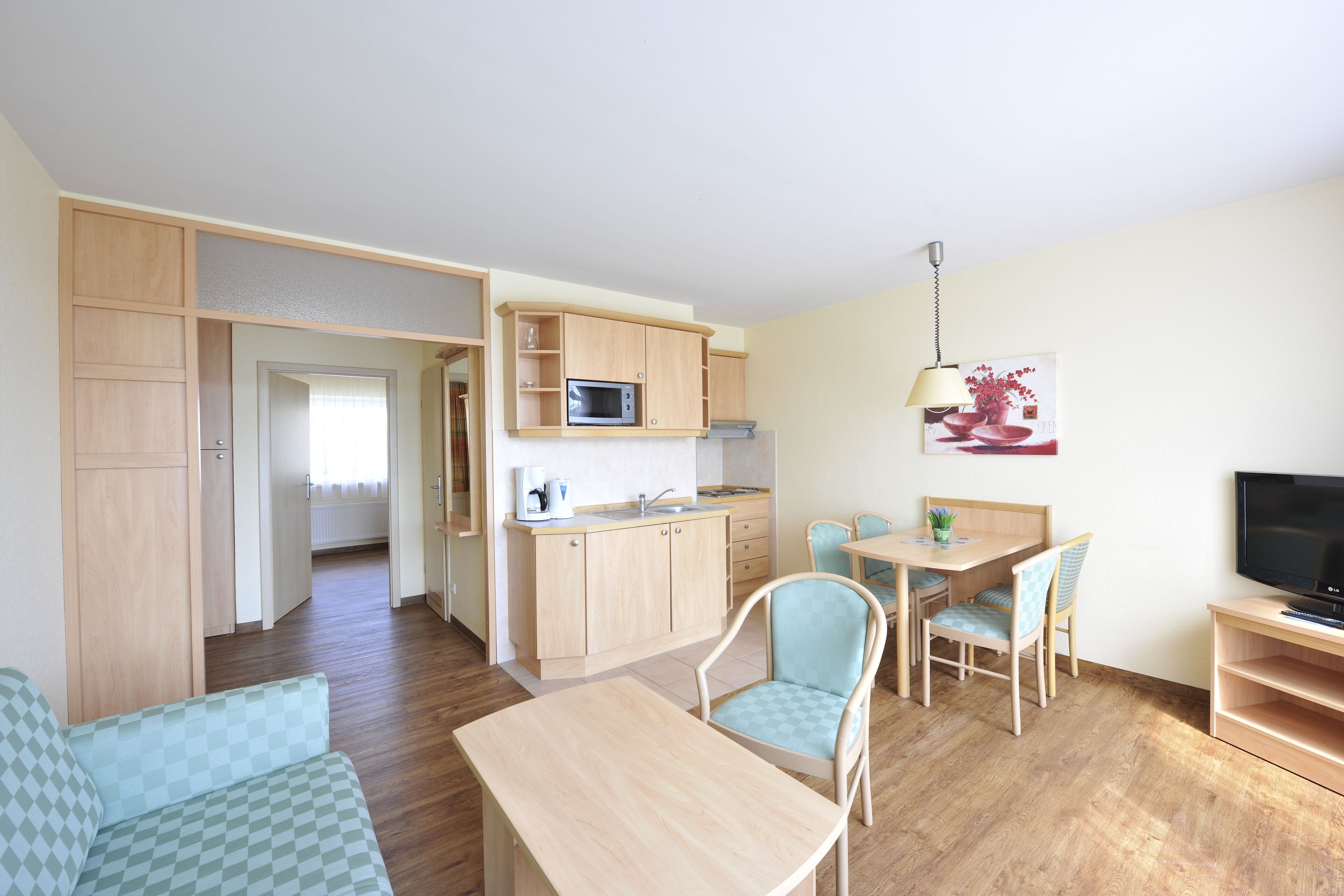 A compact living space with a kitchenette, a dining area, and a seating area.