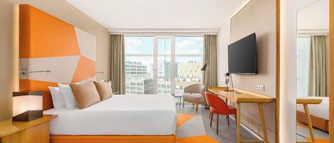 Een moderne hotelkamer met een groot bed, een bureau, een stoel en een televisie.
