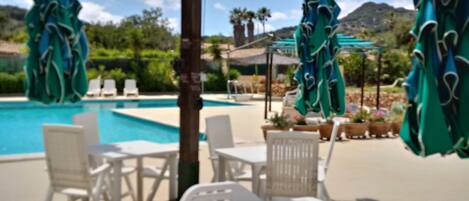 Piscine extérieure en saison, parasols, chaises longues
