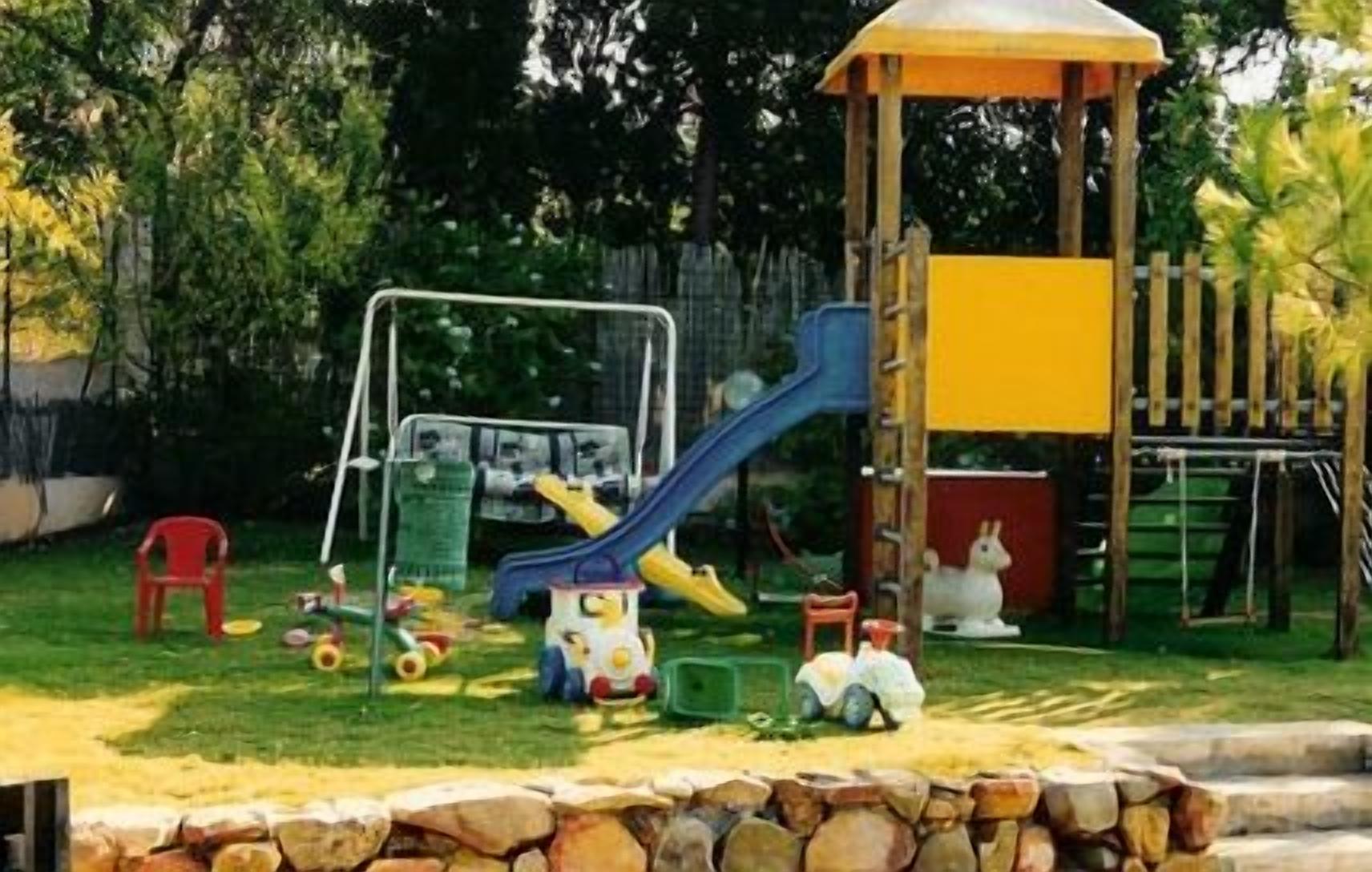 A playground with a slide, swings, and a climbing structure.