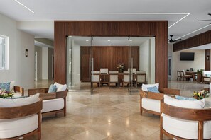 A modern interior with a dining area, wooden furniture, and a glass partition.